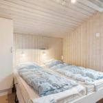 Bedroom with double bed, wood walls, and window.