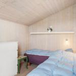 Bedroom with bed, dresser, and wood-paneled walls.