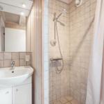 Bathroom with shower, sink, and mirror.
