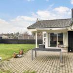 Backyard with terrace, grill area, and garden. Large glass window to interior.