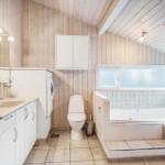 Bathroom with bathtub, toilet, and washing machine.