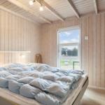 Bedroom with wooden walls, bed, and window