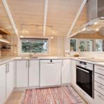 Kitchen with white cabinets, stainless steel appliances, and wooden ceiling.