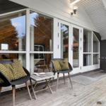 Deck with two chairs, table, and glass doors to the unit.