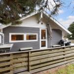 A small house with a balcony, grill, and outdoor sink.