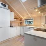 Kitchen with white cabinets, refrigerator, sink, and window.