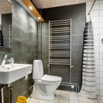 Badezimmer mit Toilette, Waschbecken und Dusche mit Duschvorhang.