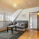 Wohnraum mit Sofa, Tisch und Holzboden unter Holzdecke
