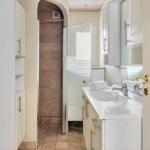 Bathroom with shower, sink, and cabinets.