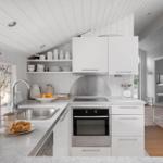 Kitchen with white cabinets, stainless steel sink, and built-in oven.
