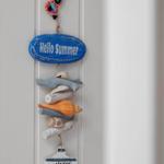 A summer decoration with seashells and a fish from Naxos hangs on the wall.