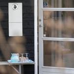 Bright door with glass panels and small table with cups and water glass.