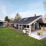 House with terrace, garden, and seating. Black facade, white veranda.