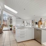 Kitchen with white built-in cabinetry, sink, and view to terrace