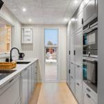 Modern kitchen with gray cabinets, countertop, and window view.