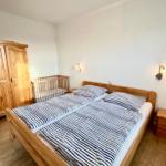 Schlafzimmer mit Ehebett Blick auf Kleiderschrank und Babybett