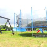 Spielplatz mit großem Trampolin und Pool im Sommer