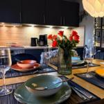 Esstisch mit Geschirr und roten Rosen im Essbereich.