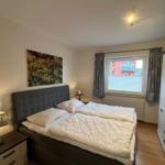 Schlafzimmer mit Doppelbett, Nachttischen und Kleiderschrank.