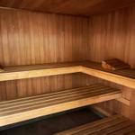 Holzsauna mit mehreren Sitzbänken und Holzverkleidung an den Wänden.