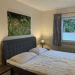 Schlafzimmer mit Bett, Nachttischen und Fenster