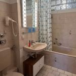 Badezimmer mit Badewanne, Spiegel und Toilette.