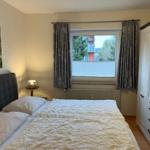 Schlafzimmer mit Bett, Kleiderschrank und Fenster mit Blick.