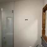 Badezimmer mit Dusche und Holzspiegelrahmen