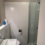 Badezimmer mit Dusche, Waschbecken und Toilette.