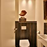 Bad mit Toilette, Waschbecken und Holzdekoration.