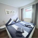 Bedroom with double bed, window, and wall art.