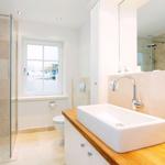 Bathroom with shower, sink, and window to pool