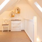 Dachgeschosszimmer mit Schrank, Stuhl und Dachschrägen.