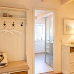 Eingangsbereich mit Garderobe, Schrank und Blick in das Bad.