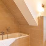 Badezimmer mit Badewanne, Toilette und Dachschrägen