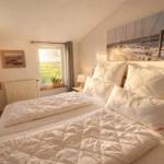 Schlafzimmer mit Doppelbett, Fenster und Wandbild.