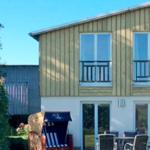 Haus mit Balkonen und Terrasse mit Gartenmöbeln und Strandkorb.