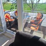 Terrace with seating area and view of green fields.