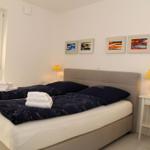 Schlafzimmer mit Doppelbett, Nachttischen und Fenster.