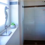 Bad mit Dusche, Fenster und Dekoration.