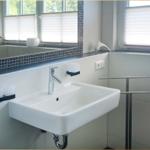 Waschbecken mit Spiegel und Fenster im Badezimmer