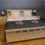 Ein Schlafzimmer mit einem Bett, zwei Nachttischen und einer gemusterten Wand.