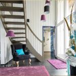 Haus mit Treppenhaus, Sitzgelegenheit und großen Fenstern.