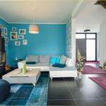 Wohnzimmer mit Sofa, Kamin und blauer Wand. Holztisch und Teppich.