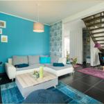 Wohnzimmer mit Sofa, Kamin und Treppe