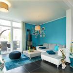 Wohnzimmer mit blauer Wand, Sofa, Kamin und Terrassentür.