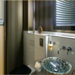 Badezimmer mit Waschbecken, Spiegel und Toilette