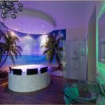 Bad mit Whirlpool, Dusche und tropischer Wandtapete.