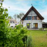 Moderne Villa mit Terrasse und Garten. Umgeben von Bäumen und Grün.