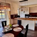 Raum mit gemütlicher Sitzecke und 65 Zoll TV Offener Küche mit Tresen und Kochinsel. Essecke mit 6 Plätzen. Blick auf die Felder. und d...